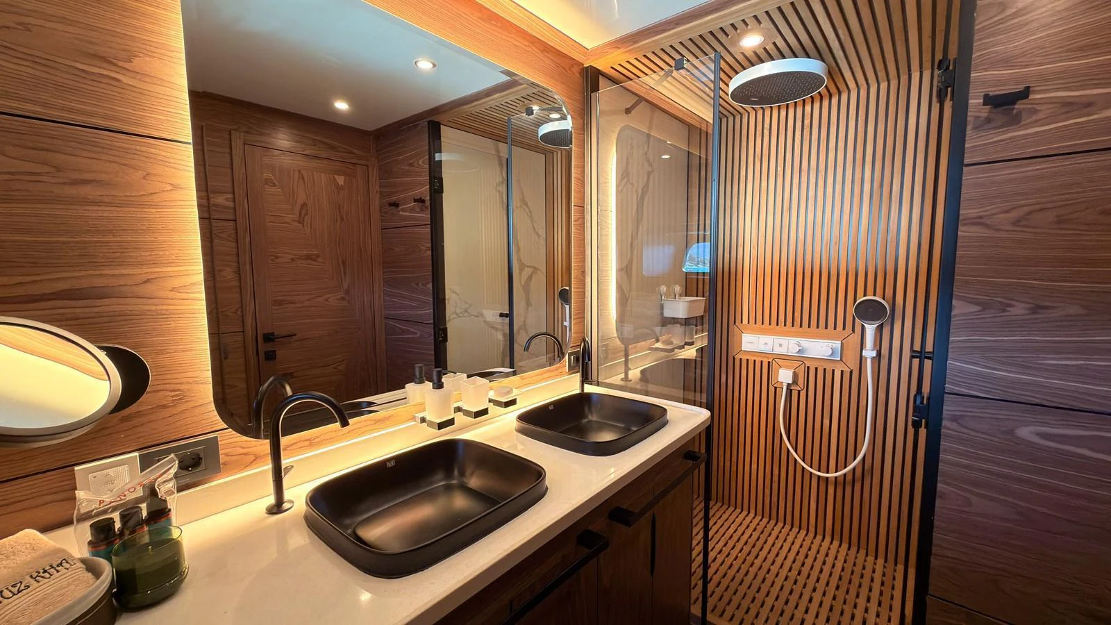 The yacht's bathroom features a modern design with dual sinks and a spacious shower area. aboard OGUZ KHAN Yacht for Sale