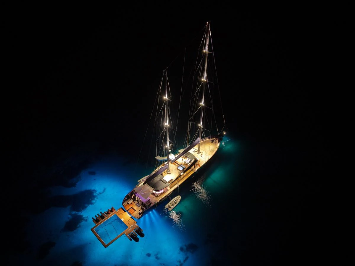 A stunning yacht illuminated at night, showcasing its elegant design and serene surroundings. aboard OGUZ KHAN Yacht for Sale
