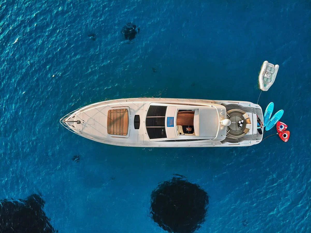 A sleek yacht is anchored in clear blue waters, viewed from above. aboard RIVA 72' Yacht for Sale