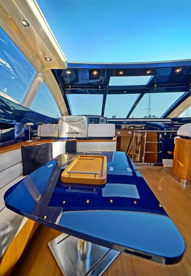 The saloon features a sleek, modern design with a glossy table and expansive windows offering panoramic views. aboard RIVA 72' Yacht for Sale