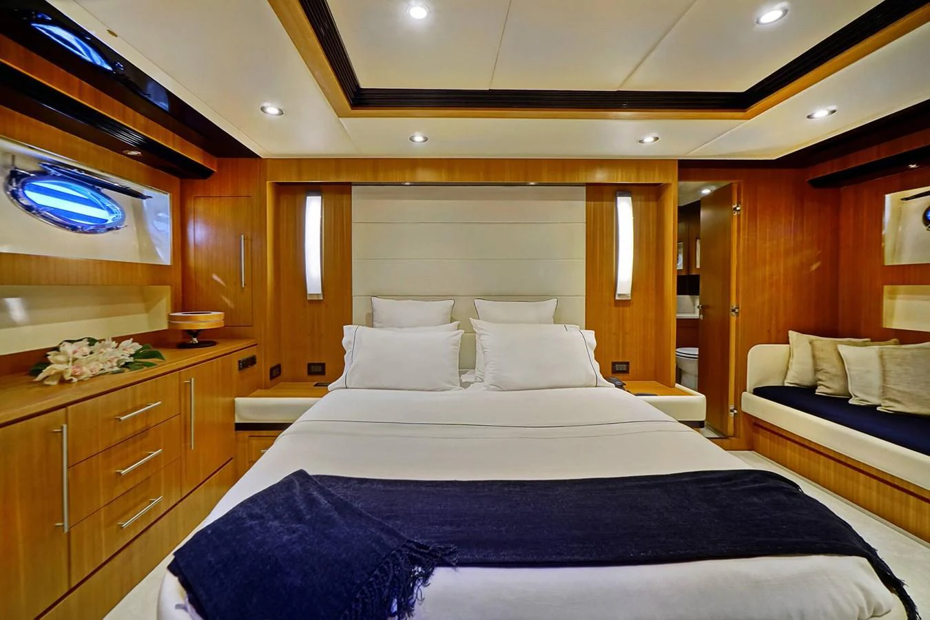 The master stateroom features a luxurious bed with elegant wood finishes and ample lighting. aboard RIVA 72' Yacht for Sale