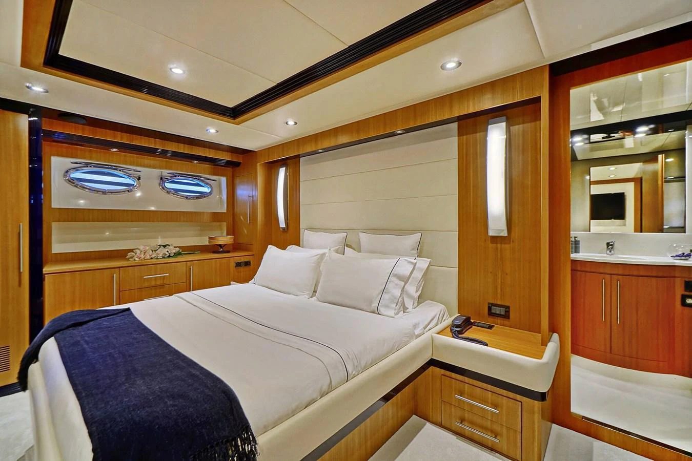 The stateroom features a luxurious bed with elegant wood paneling and modern lighting. aboard RIVA 72' Yacht for Sale