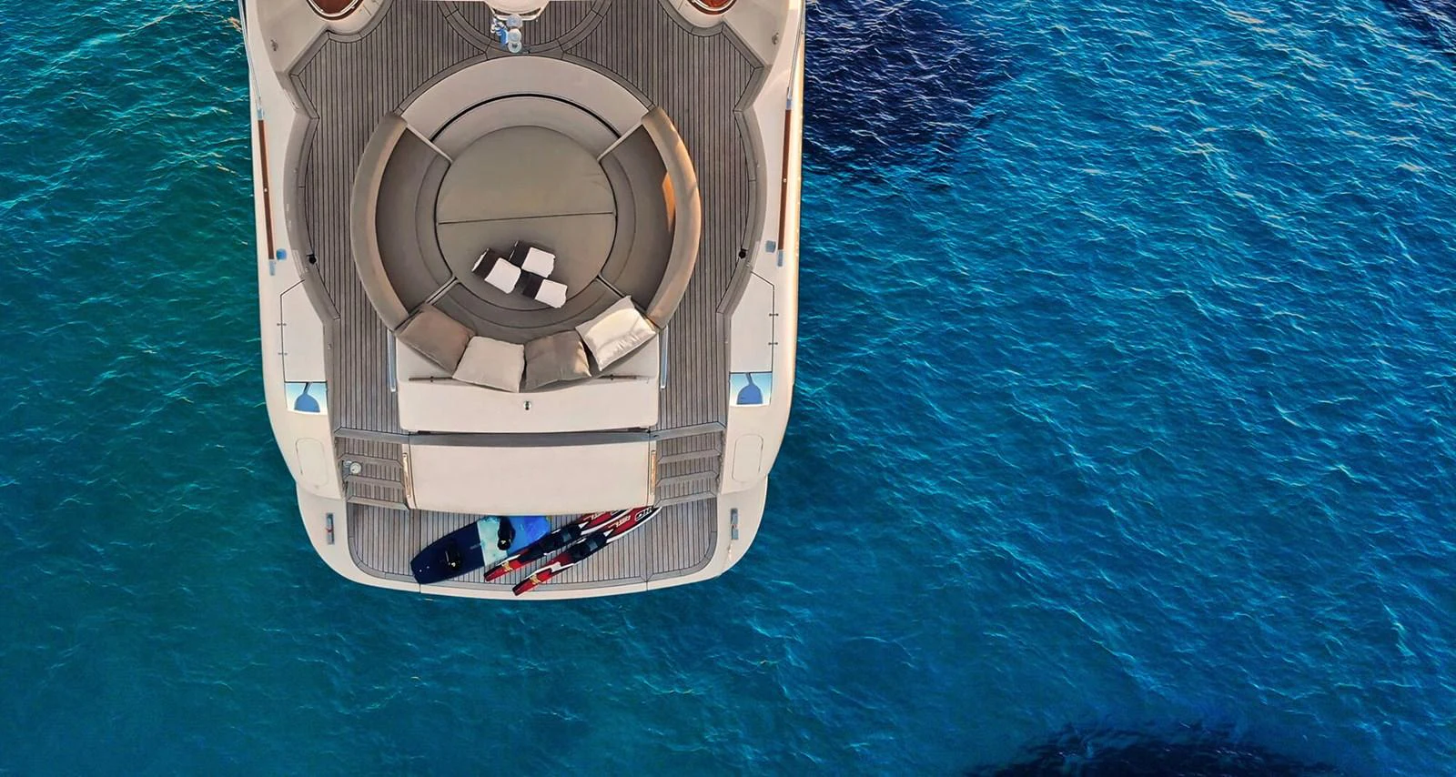 The aft deck of the yacht features a luxurious seating area with a view of the clear blue water. aboard RIVA 72' Yacht for Sale