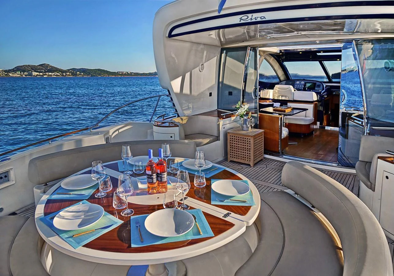 The aft deck features an elegant dining area with a stunning view of the sea. aboard RIVA 72' Yacht for Sale