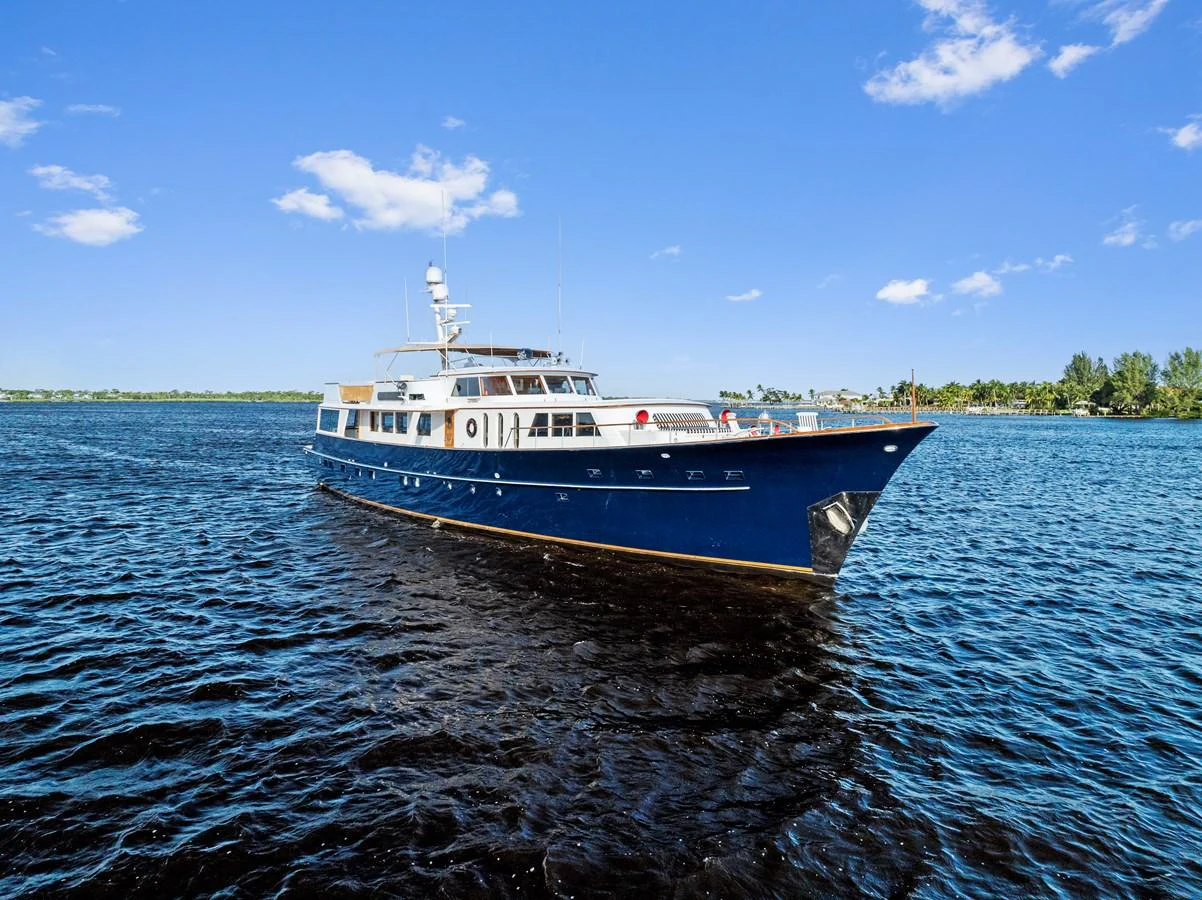 A stunning yacht glides gracefully on the water under a clear blue sky. aboard CHANTICLEER Yacht for Sale