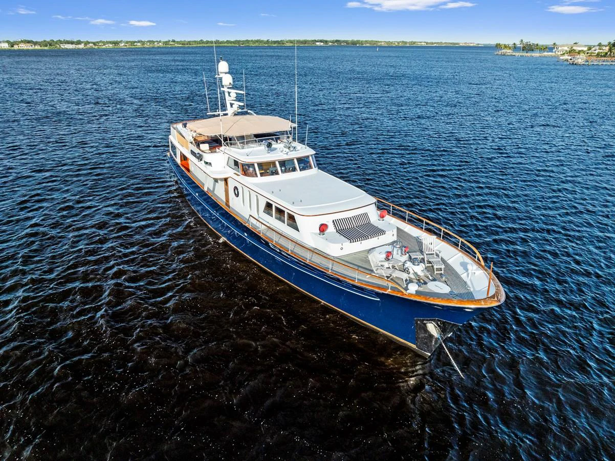 A sleek yacht glides gracefully on calm waters, showcasing its elegant design and spacious deck areas. aboard CHANTICLEER Yacht for Sale