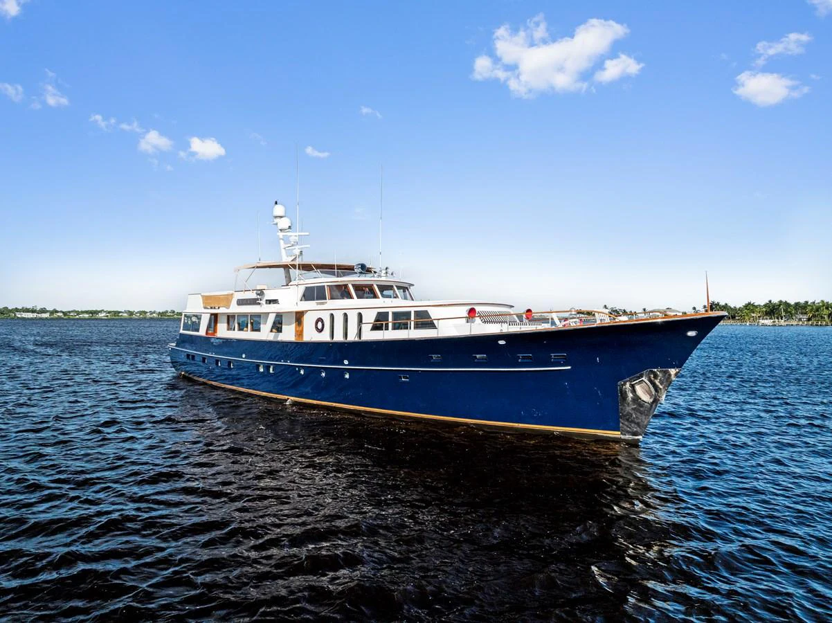 A classic yacht glides gracefully on calm waters under a clear blue sky. aboard CHANTICLEER Yacht for Sale