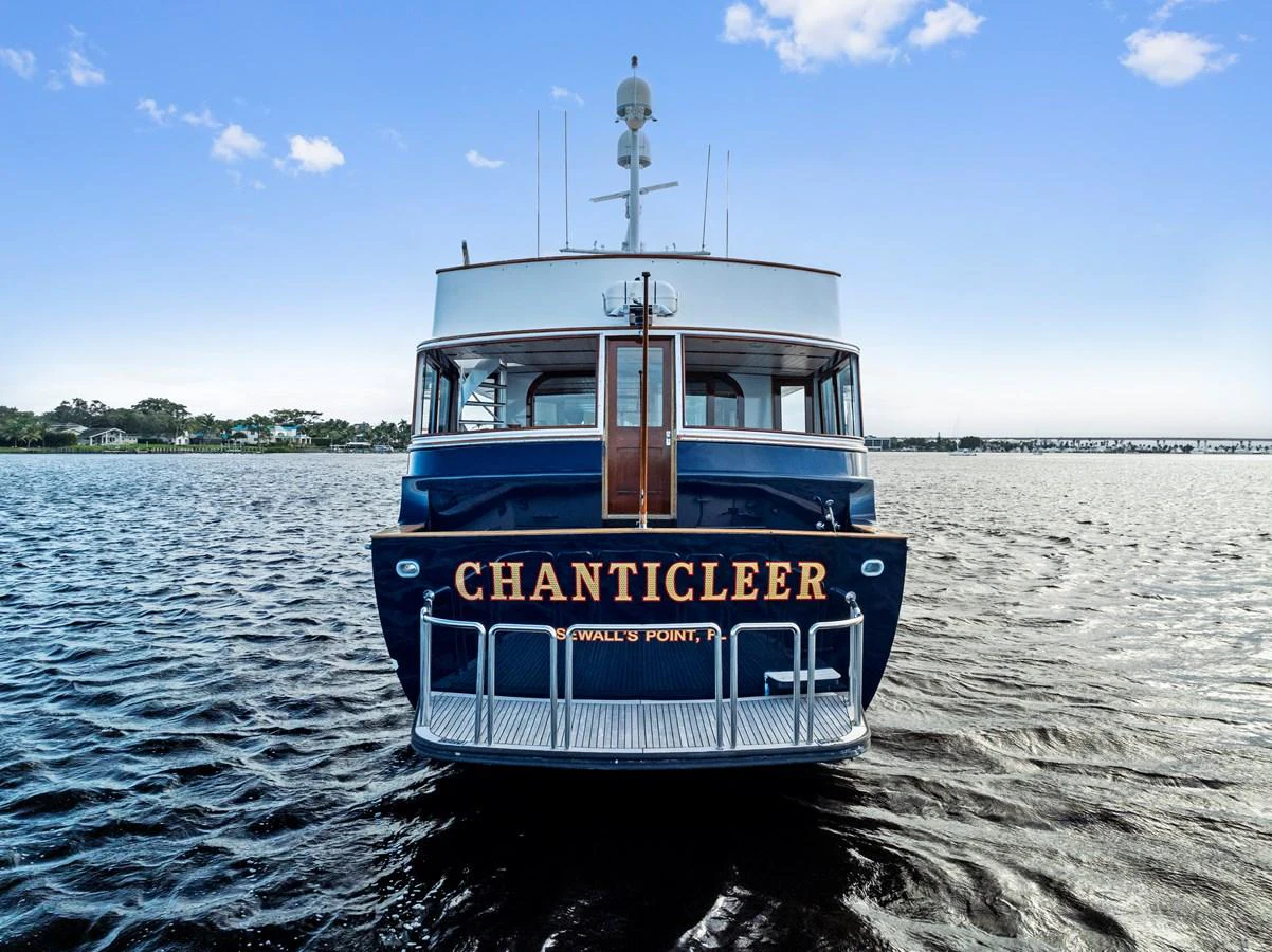 A classic yacht is seen from the stern, showcasing its elegant design and name. aboard CHANTICLEER Yacht for Sale