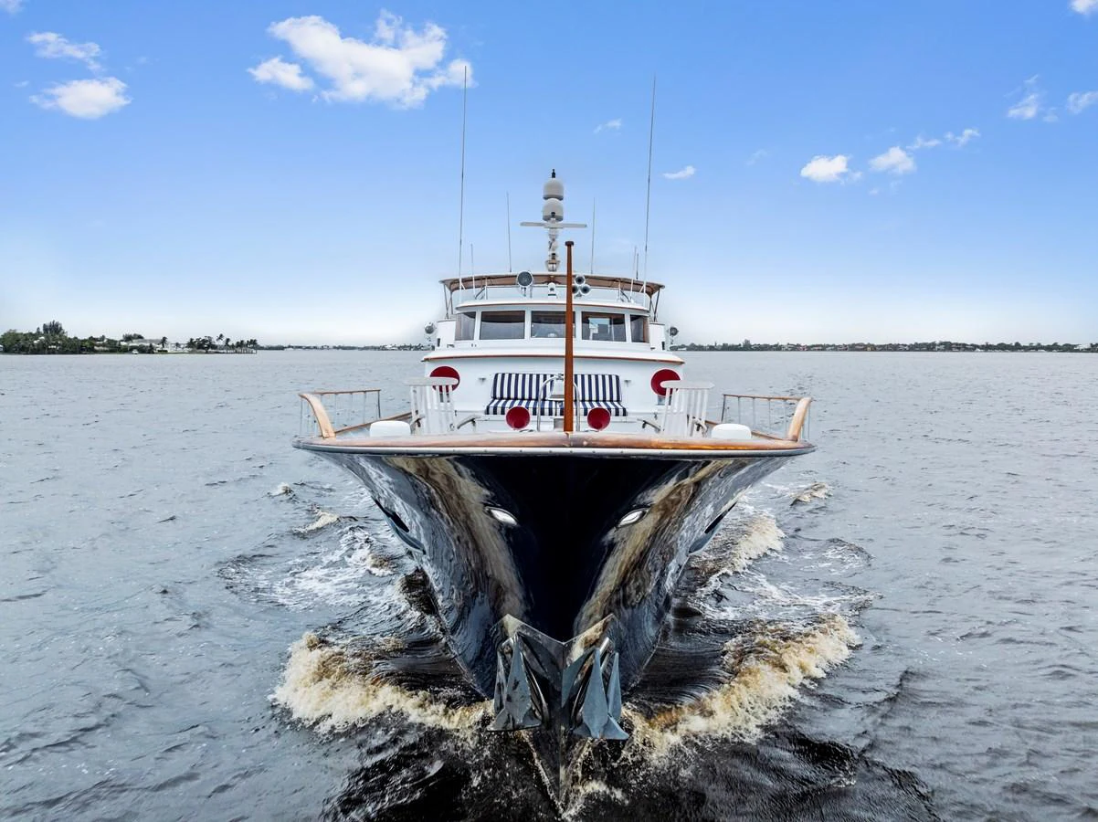 A majestic yacht cruises through calm waters under a clear blue sky. aboard CHANTICLEER Yacht for Sale