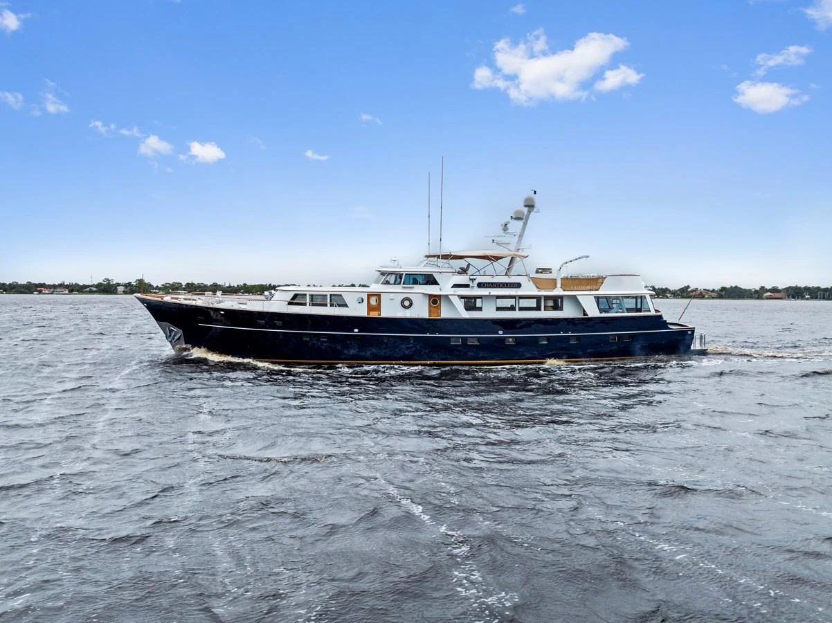 A classic yacht cruises gracefully on open waters under a clear blue sky. aboard CHANTICLEER Yacht for Sale