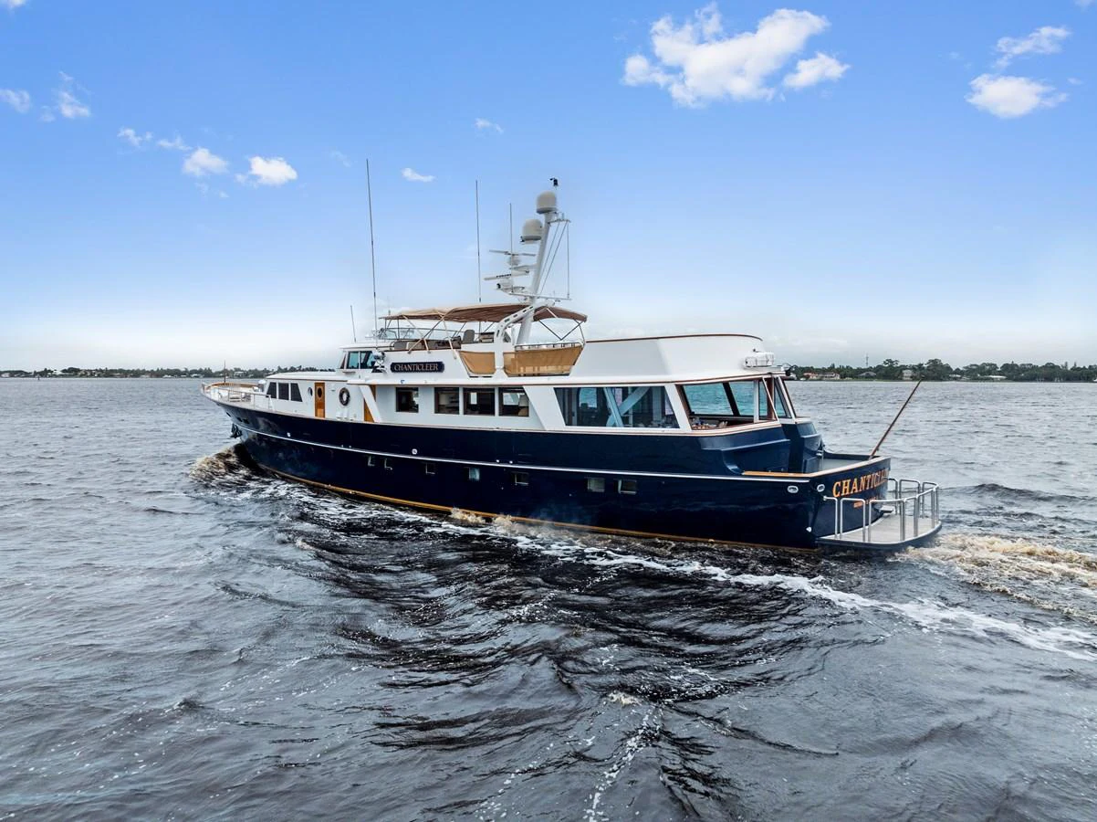 A classic yacht cruises gracefully on calm waters under a clear blue sky. aboard CHANTICLEER Yacht for Sale