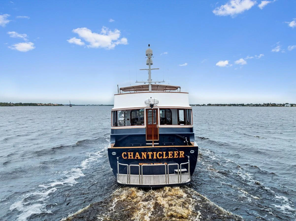 A classic yacht navigates through calm waters, showcasing its elegant stern design. aboard CHANTICLEER Yacht for Sale