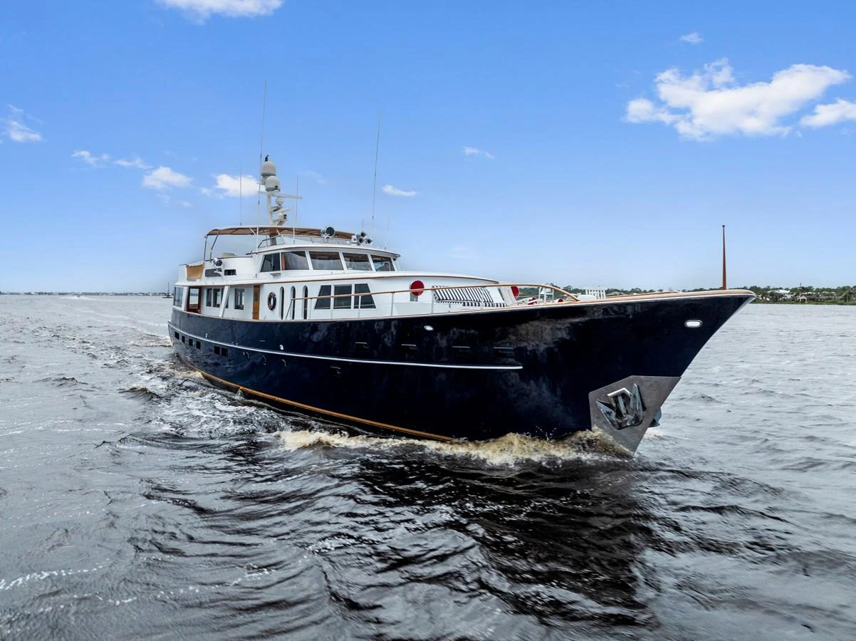 A classic yacht cruises gracefully through calm waters under a clear blue sky. aboard CHANTICLEER Yacht for Sale