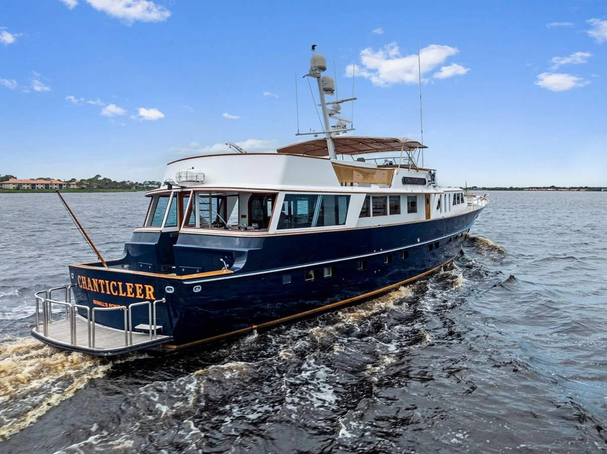 A classic yacht cruises smoothly on calm waters under a clear blue sky. aboard CHANTICLEER Yacht for Sale
