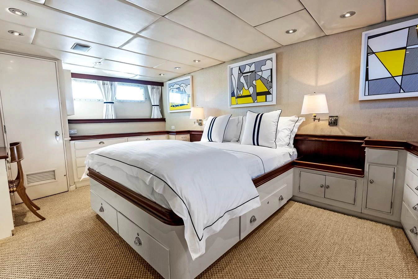 The stateroom features a comfortable bed with elegant bedding and modern artwork on the walls. aboard CHANTICLEER Yacht for Sale