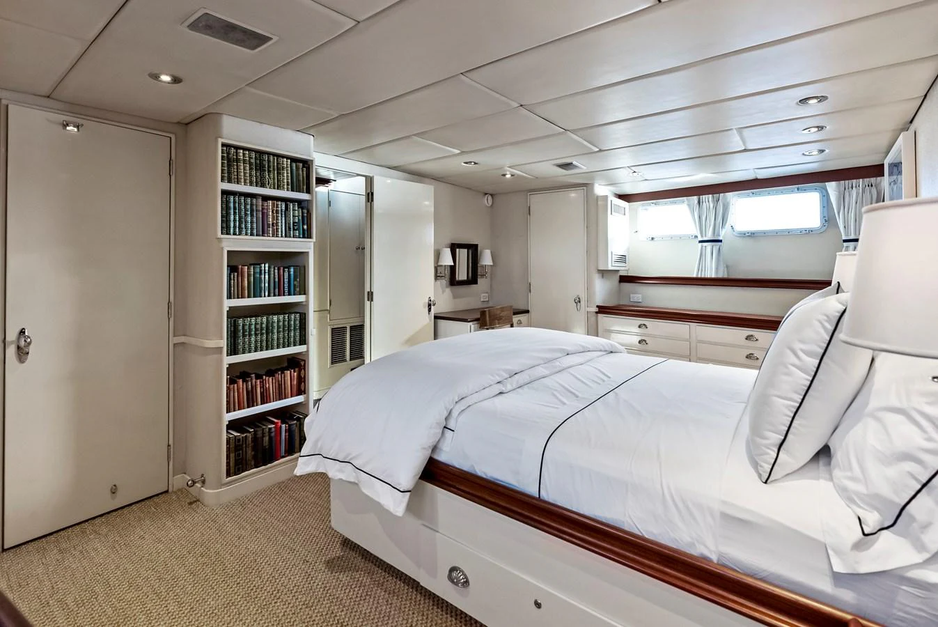 The stateroom features a cozy bed, built-in bookshelves, and ample storage, creating a comfortable and inviting space. aboard CHANTICLEER Yacht for Sale