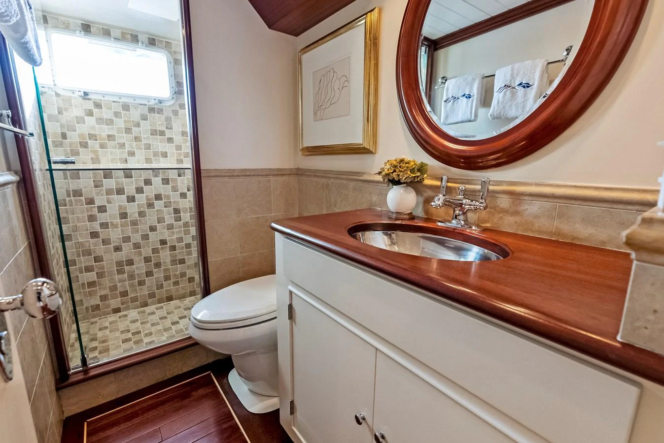 The yacht's bathroom features a stylish design with a wooden countertop and a glass-enclosed shower. aboard CHANTICLEER Yacht for Sale