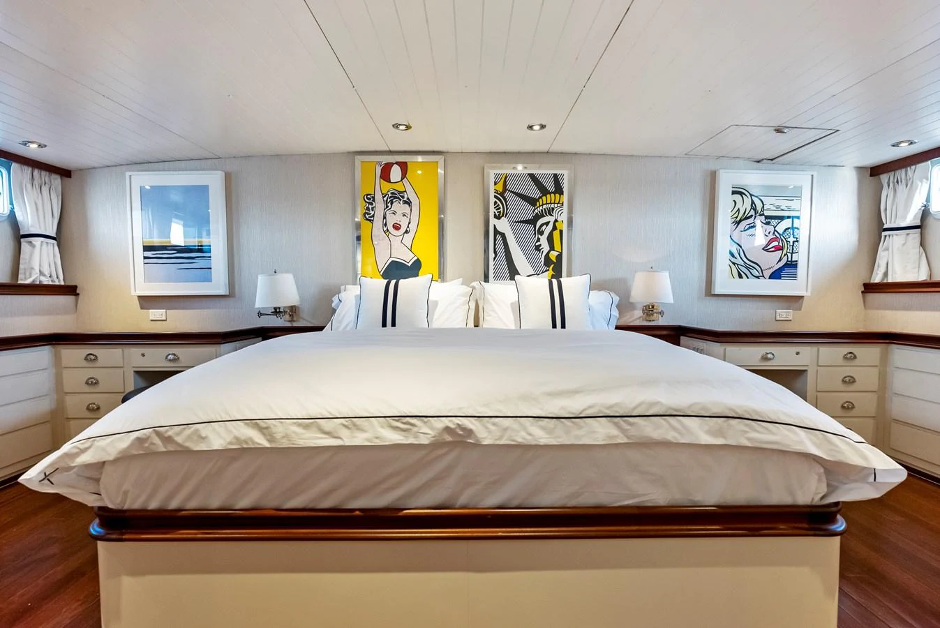The master stateroom features a spacious bed with elegant bedding and contemporary artwork on the walls. aboard CHANTICLEER Yacht for Sale