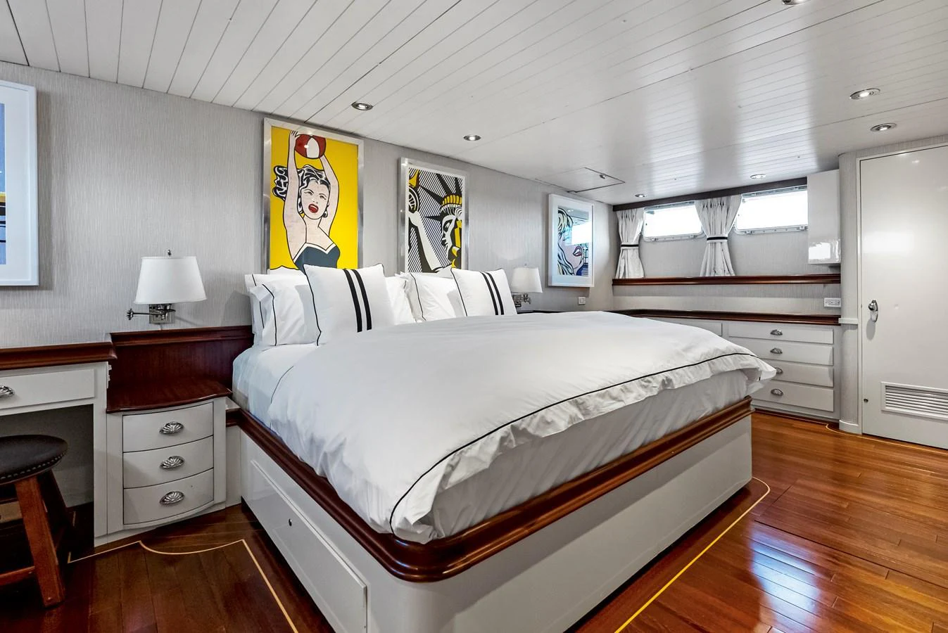 The stateroom features a spacious bed with modern artwork and ample natural light. aboard CHANTICLEER Yacht for Sale