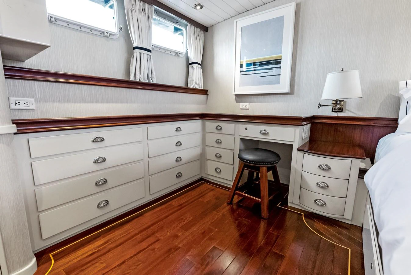 This cozy cabin features ample storage with built-in drawers and a comfortable seating area. aboard CHANTICLEER Yacht for Sale