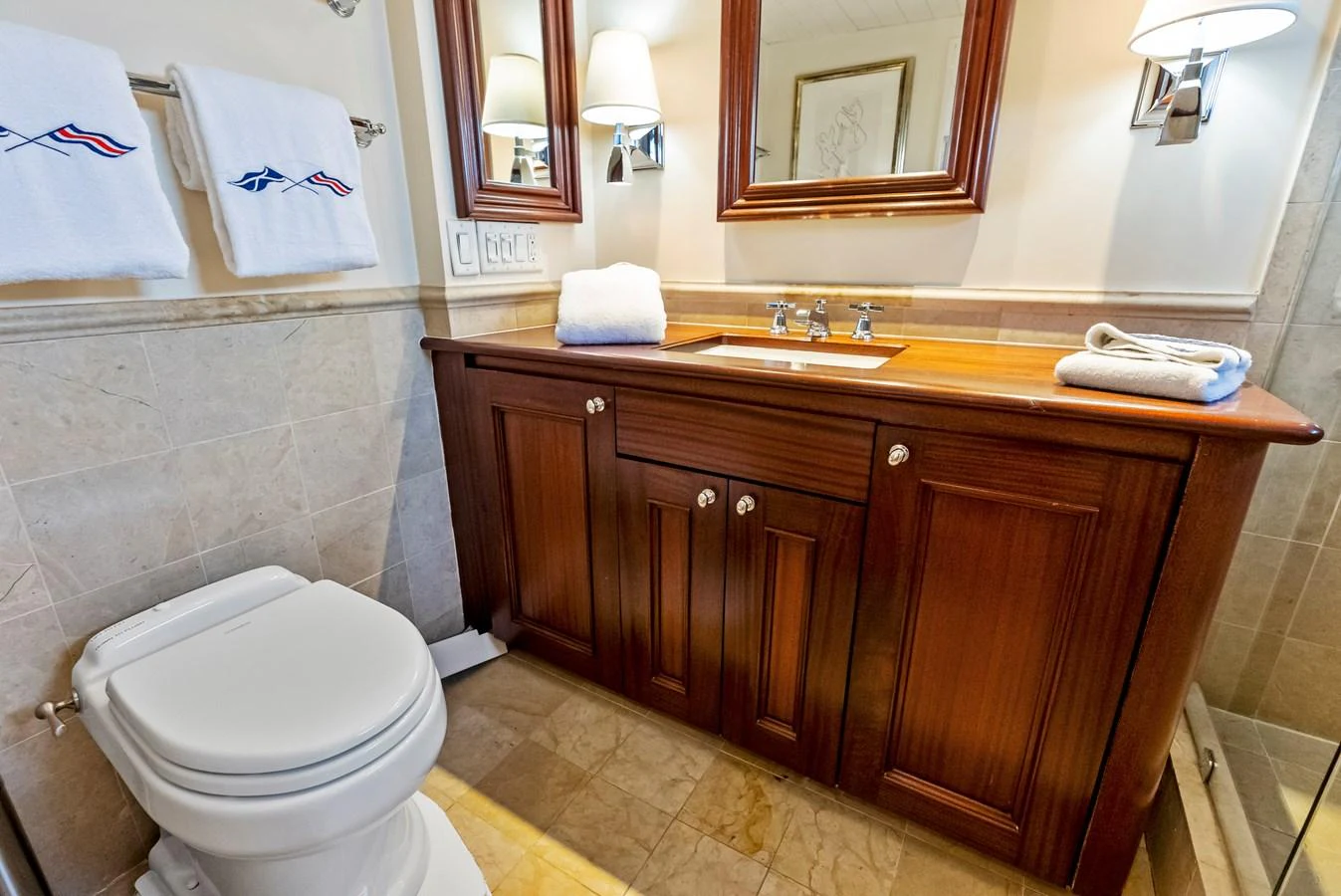 The yacht's bathroom features elegant wooden cabinetry and modern fixtures. aboard CHANTICLEER Yacht for Sale