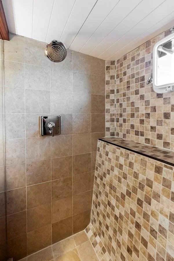 The yacht features a modern shower with elegant tiling and a sleek showerhead. aboard CHANTICLEER Yacht for Sale