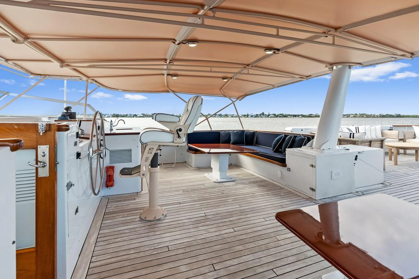 The flybridge offers a spacious and shaded area with comfortable seating and a helm station. aboard CHANTICLEER Yacht for Sale