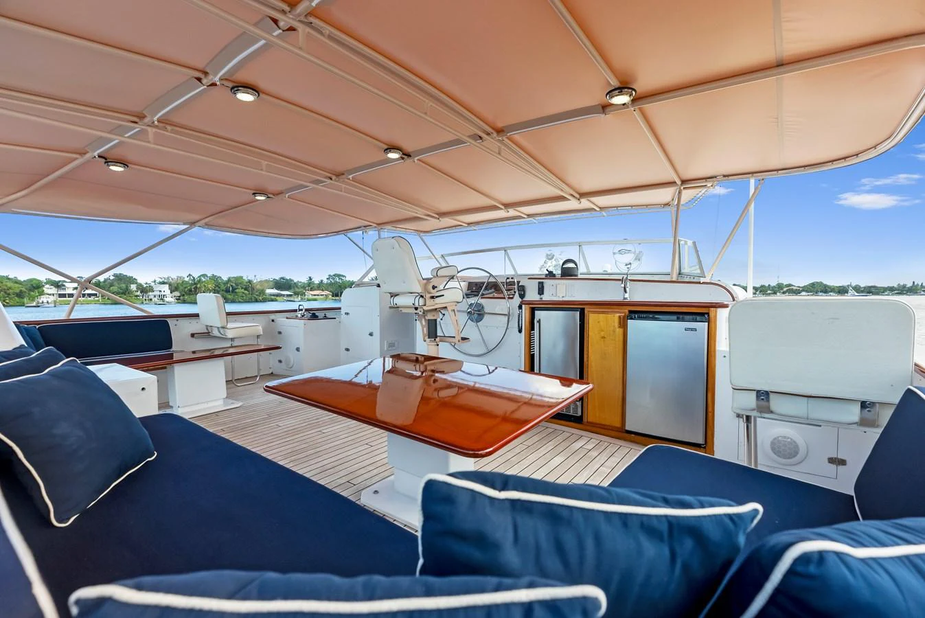 The flybridge features comfortable seating with navy cushions and a well-equipped helm station. aboard CHANTICLEER Yacht for Sale
