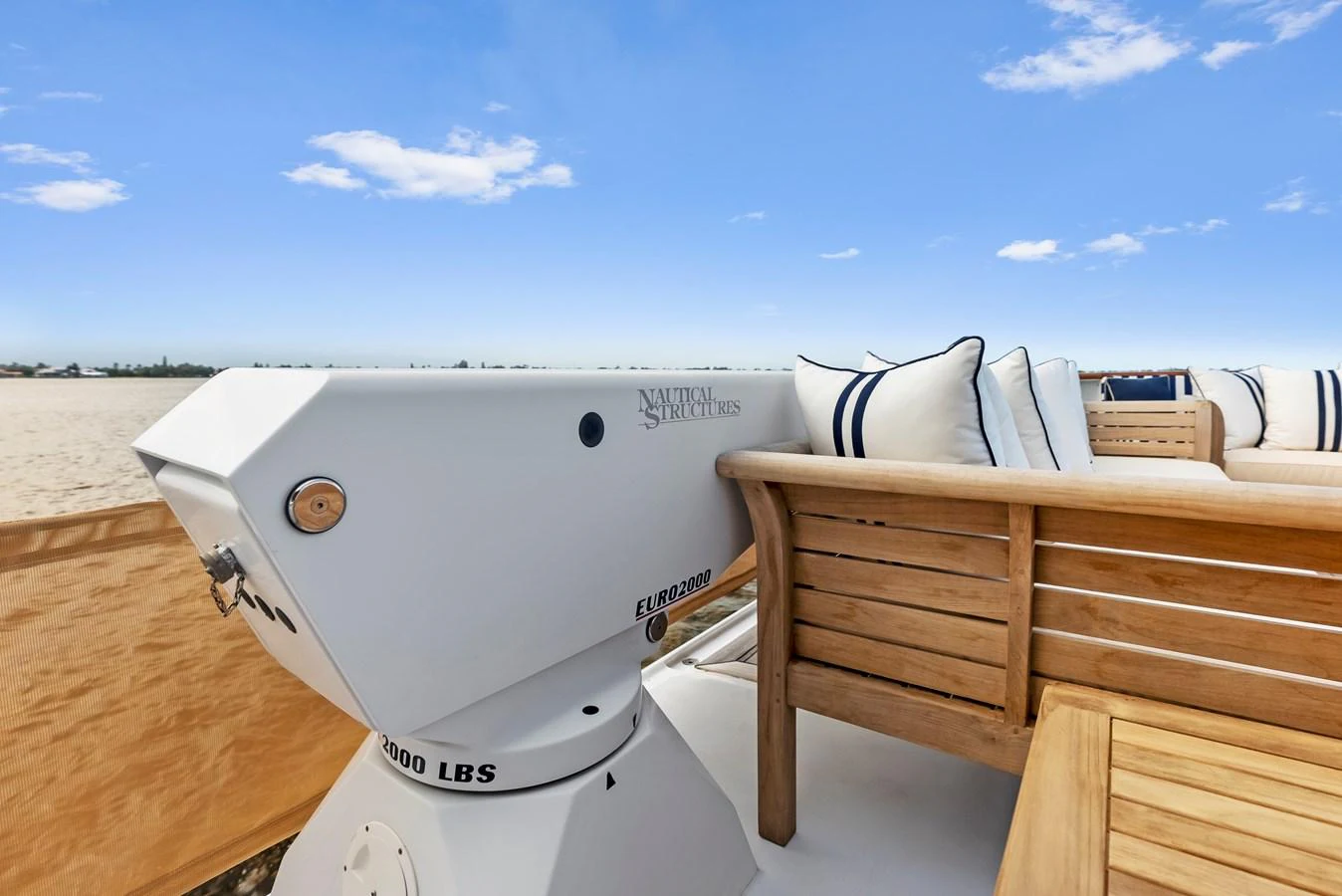 A close-up view of a yacht's deck featuring a wooden seating area and a winch. aboard CHANTICLEER Yacht for Sale