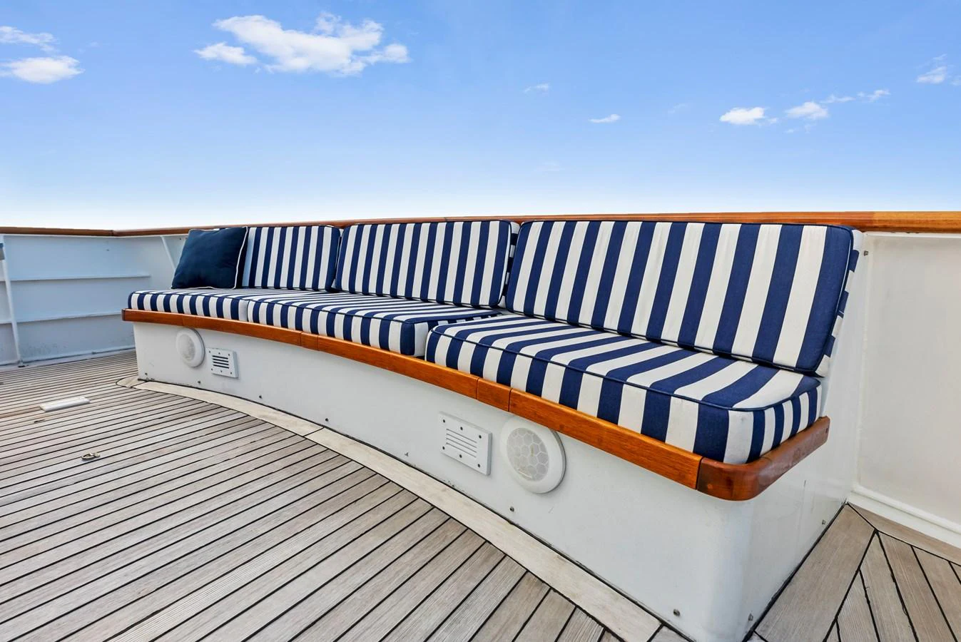 The yacht features a stylish deck seating area with blue and white striped cushions, perfect for relaxation. aboard CHANTICLEER Yacht for Sale