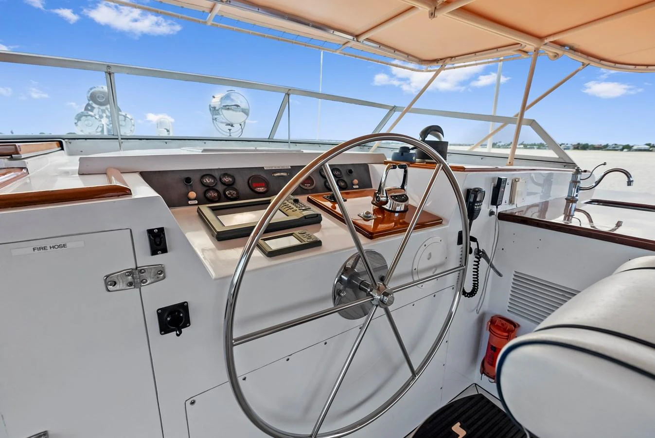 The helm station features a large steering wheel and an array of navigational instruments under a shaded canopy. aboard CHANTICLEER Yacht for Sale
