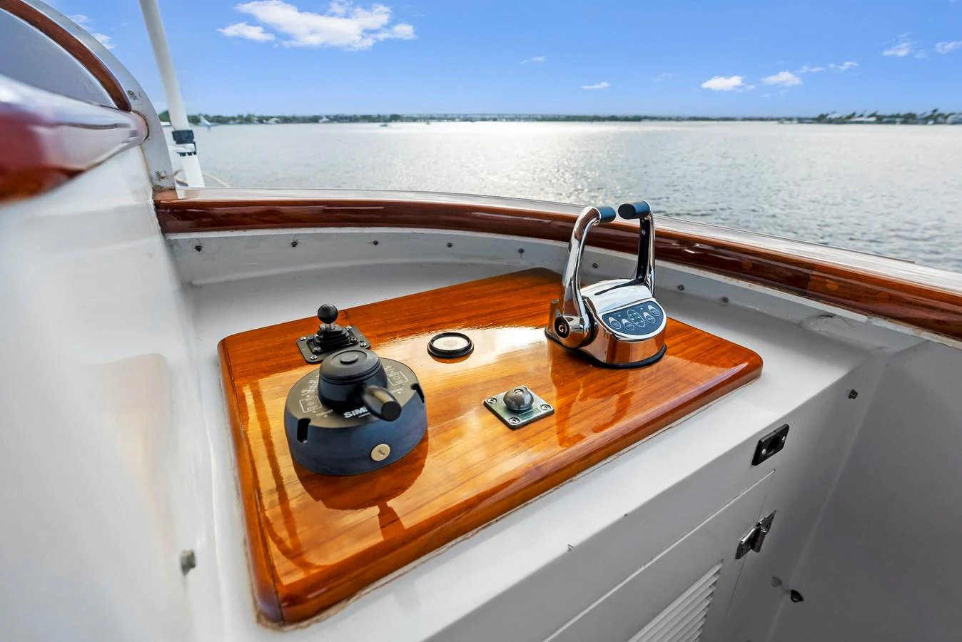A close-up view of the helm station with polished wooden accents and modern controls. aboard CHANTICLEER Yacht for Sale