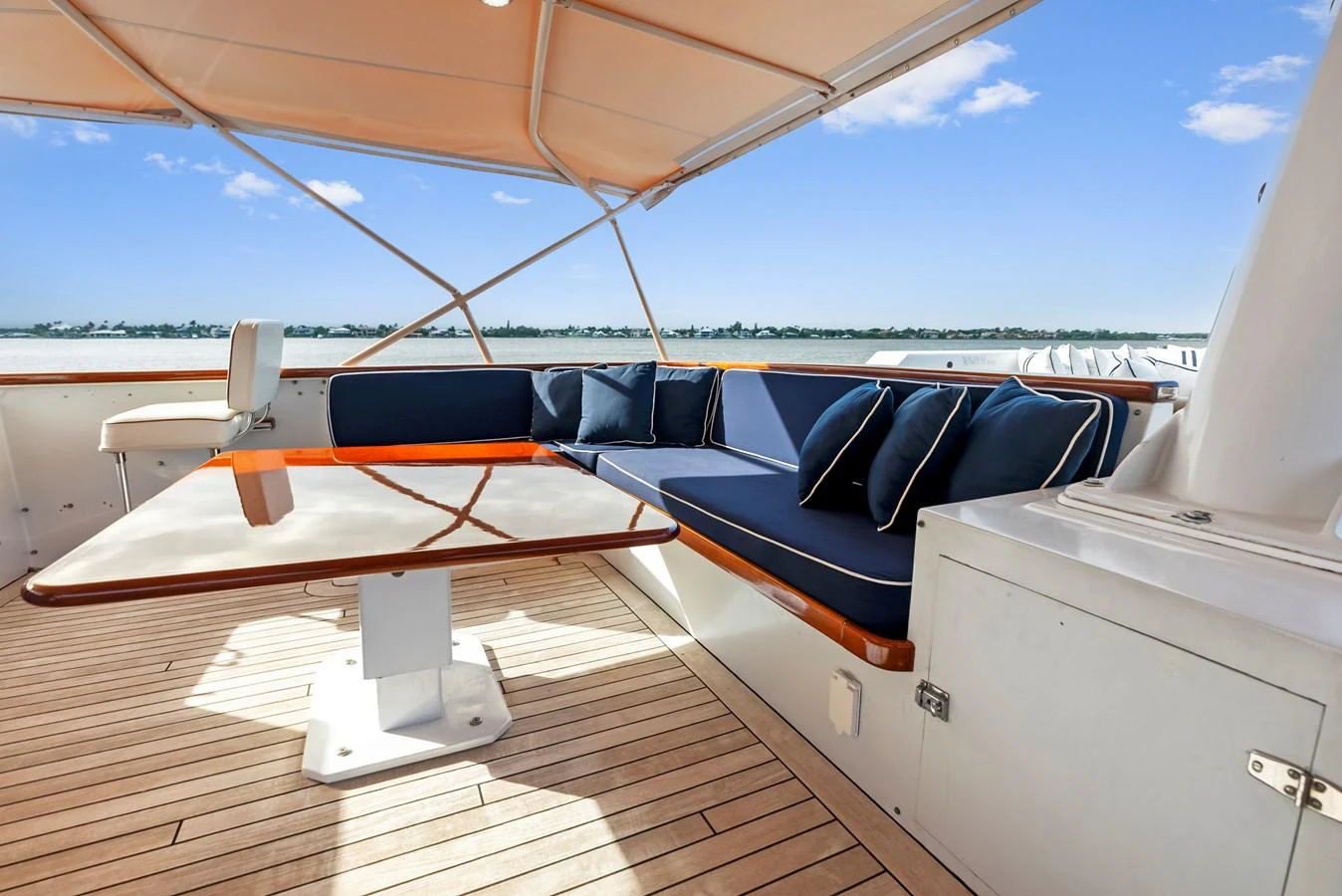 The aft deck features a comfortable seating area with a table, perfect for outdoor relaxation and dining. aboard CHANTICLEER Yacht for Sale
