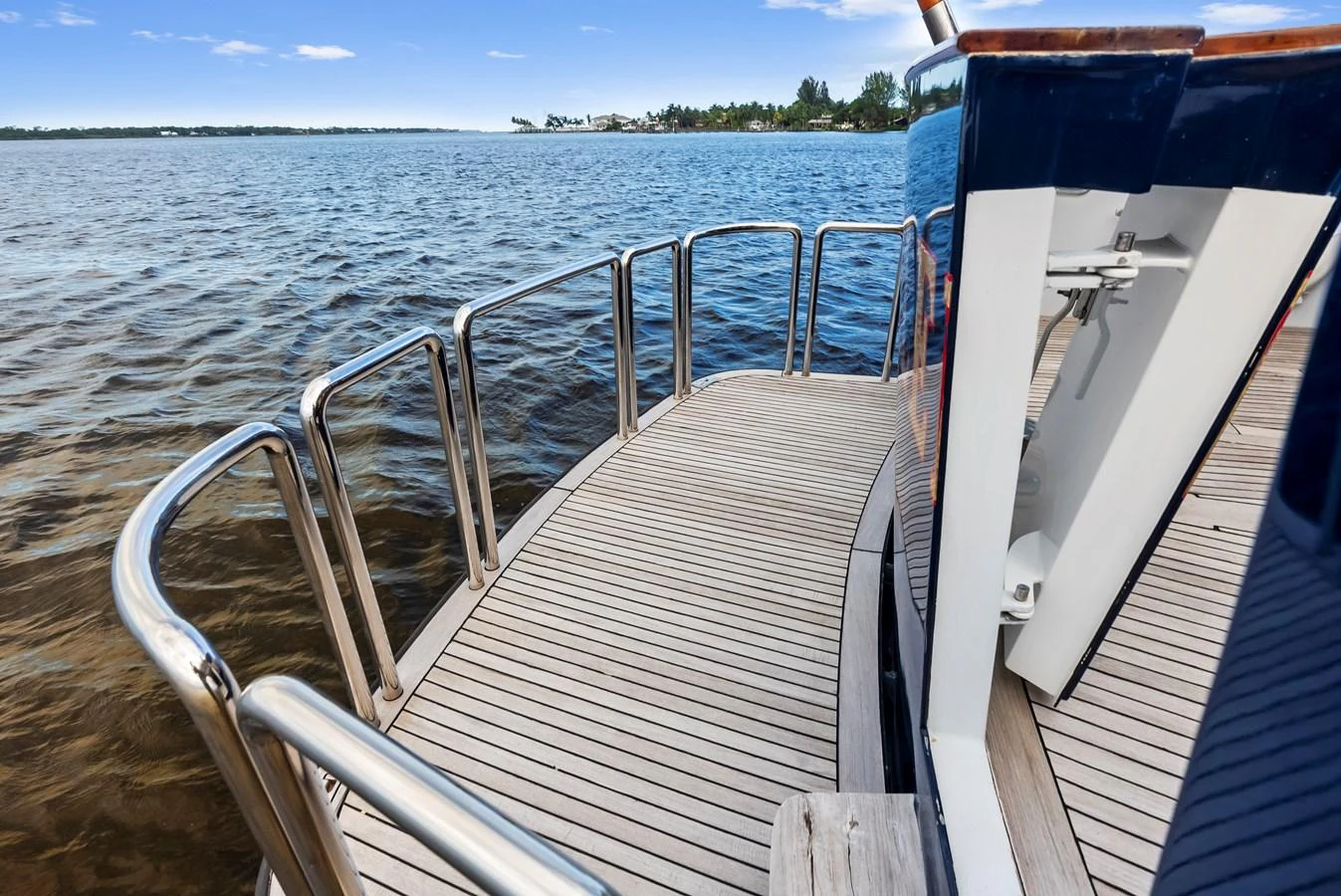 The yacht's side deck features sleek wooden flooring and polished railings, offering a safe and stylish passage along the vessel. aboard CHANTICLEER Yacht for Sale