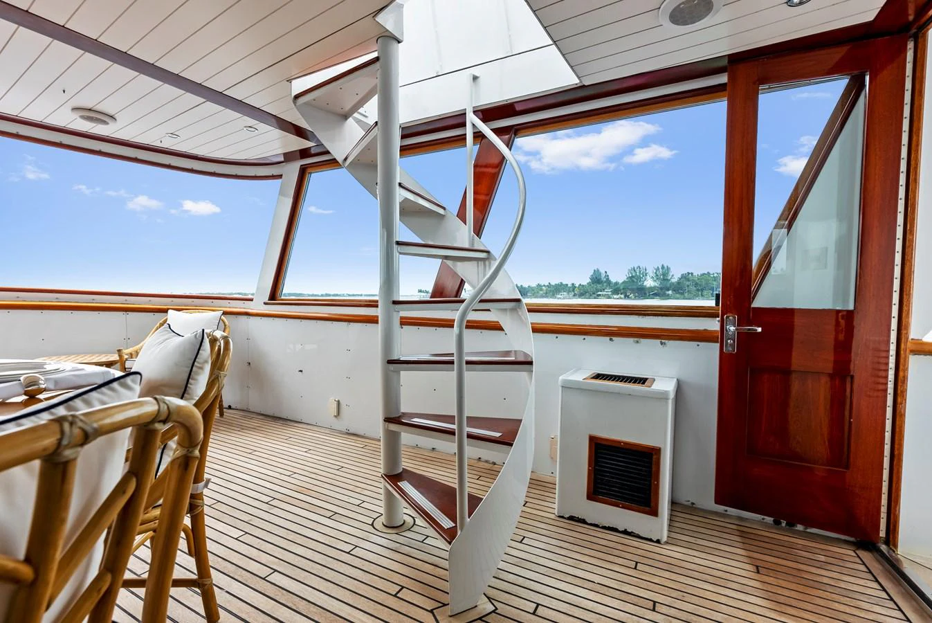 The salon features a spiral staircase and large windows offering panoramic views. aboard CHANTICLEER Yacht for Sale