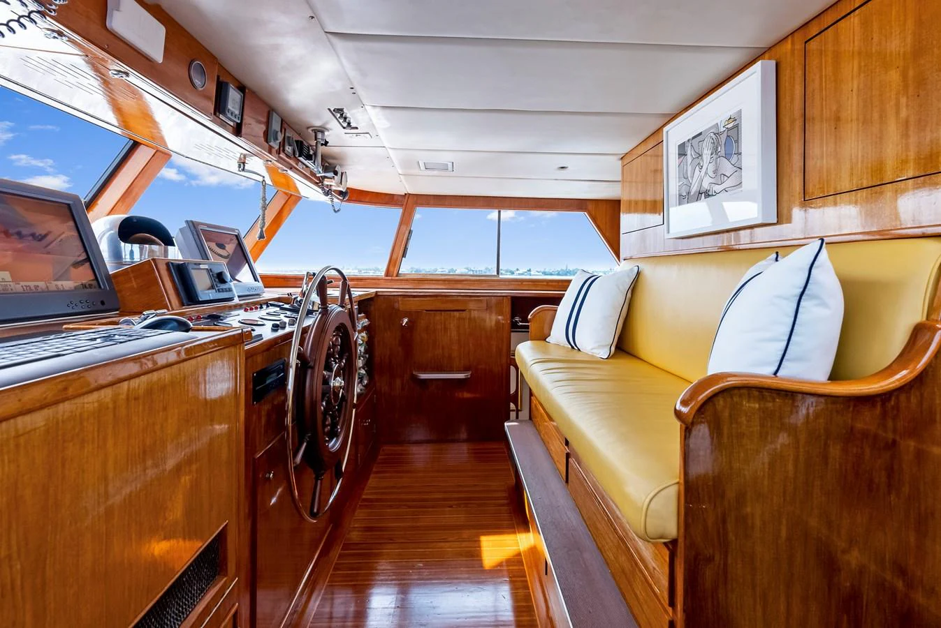 The helm station features a classic wooden design with modern navigation equipment and a comfortable seating area. aboard CHANTICLEER Yacht for Sale