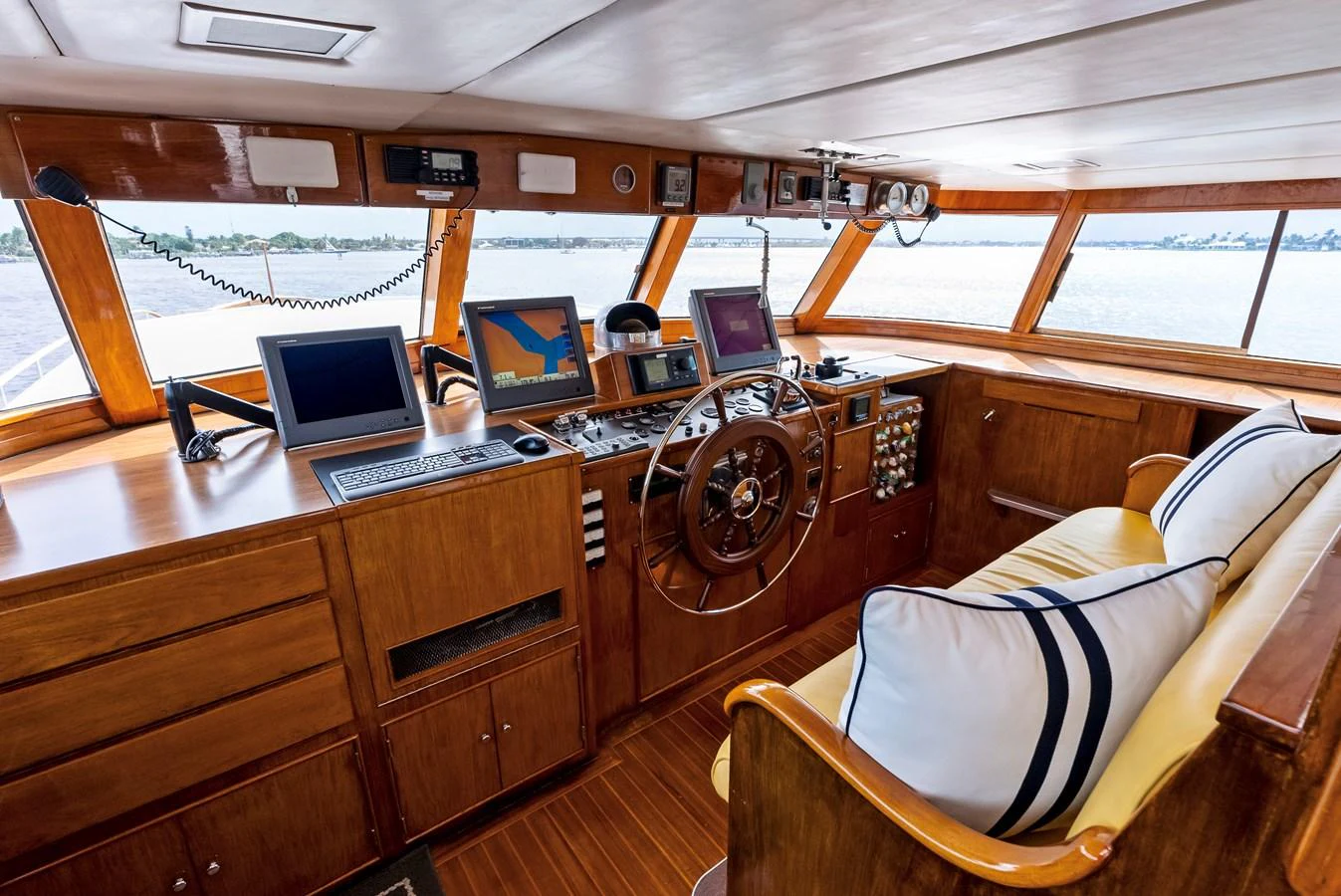 The helm station features classic wooden finishes and modern navigation equipment, offering a blend of tradition and technology. aboard CHANTICLEER Yacht for Sale