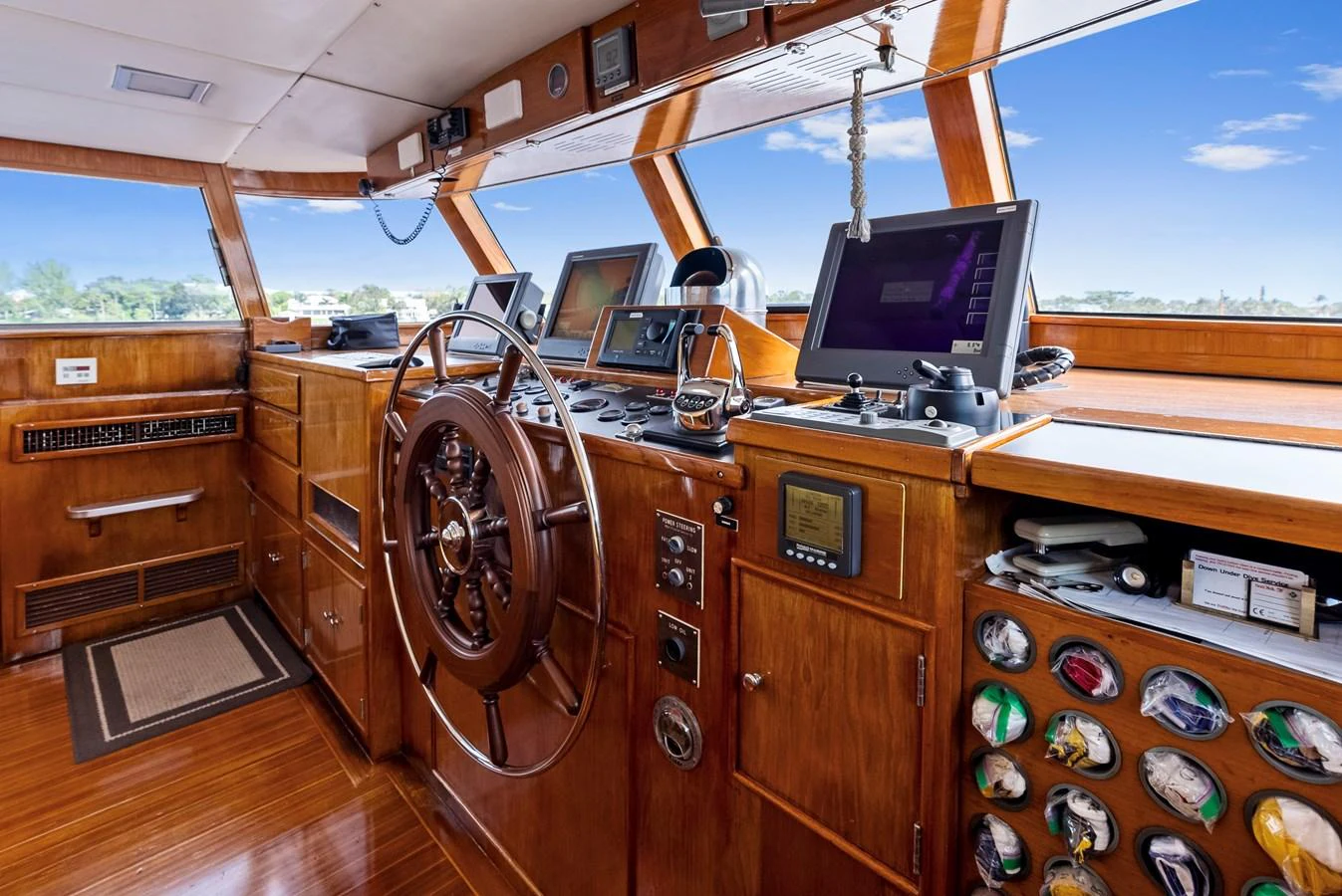 The helm station features classic wooden finishes and modern navigation equipment. aboard CHANTICLEER Yacht for Sale