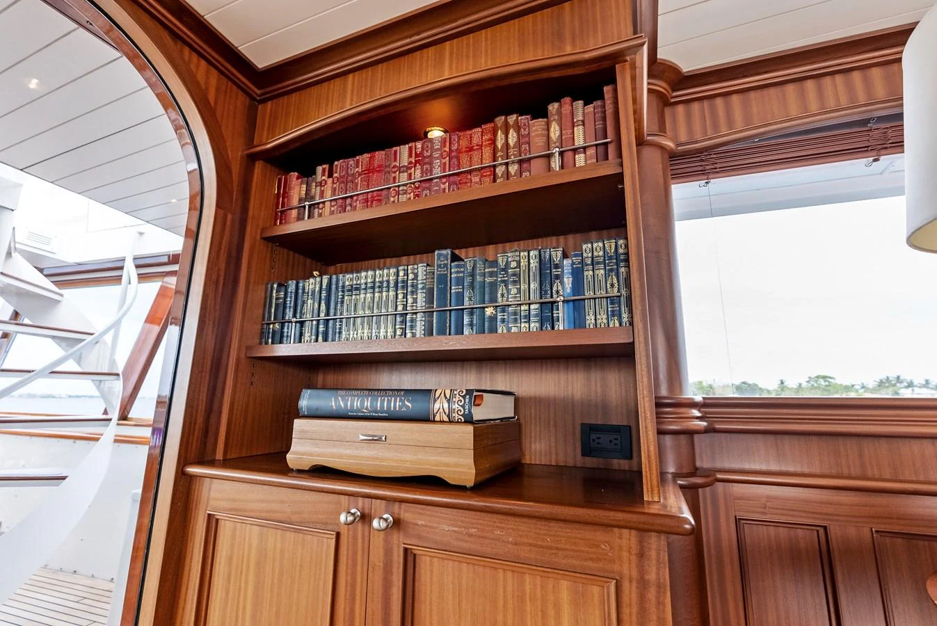A refined interior library area featuring wooden cabinetry and a collection of books. aboard CHANTICLEER Yacht for Sale