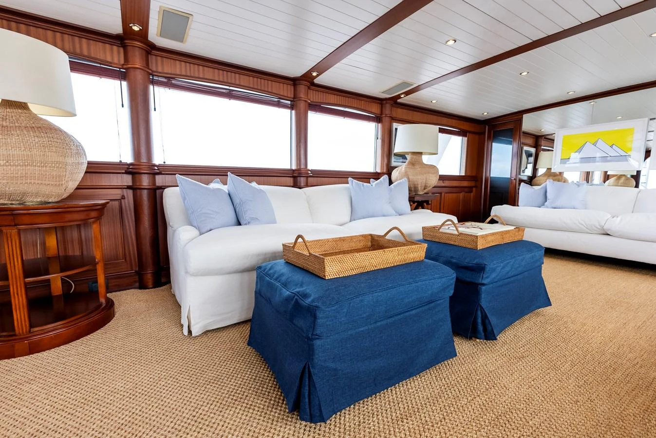 The salon features comfortable seating with a blend of natural and nautical decor. aboard CHANTICLEER Yacht for Sale