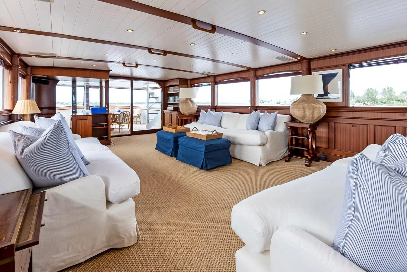 The salon features plush white sofas, wooden accents, and large windows offering panoramic views. aboard CHANTICLEER Yacht for Sale