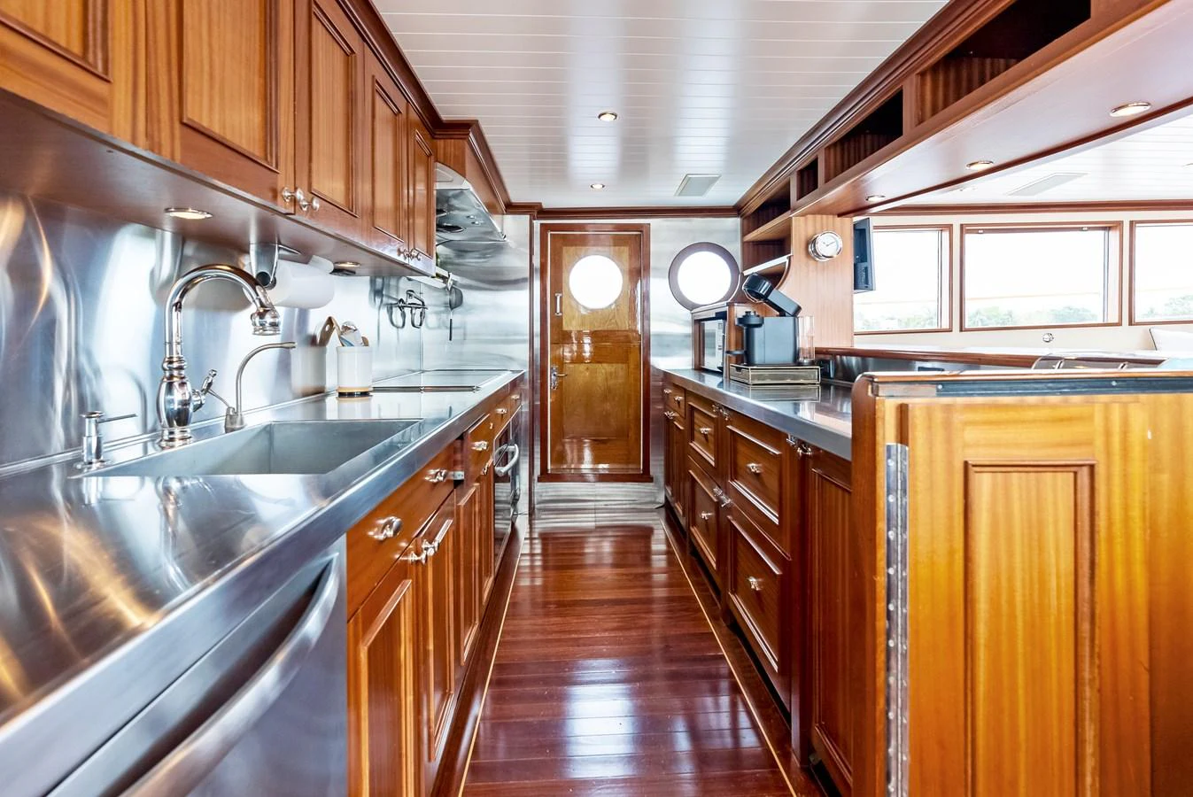The yacht's galley features rich wooden cabinetry and stainless steel appliances, creating a warm and functional space. aboard CHANTICLEER Yacht for Sale