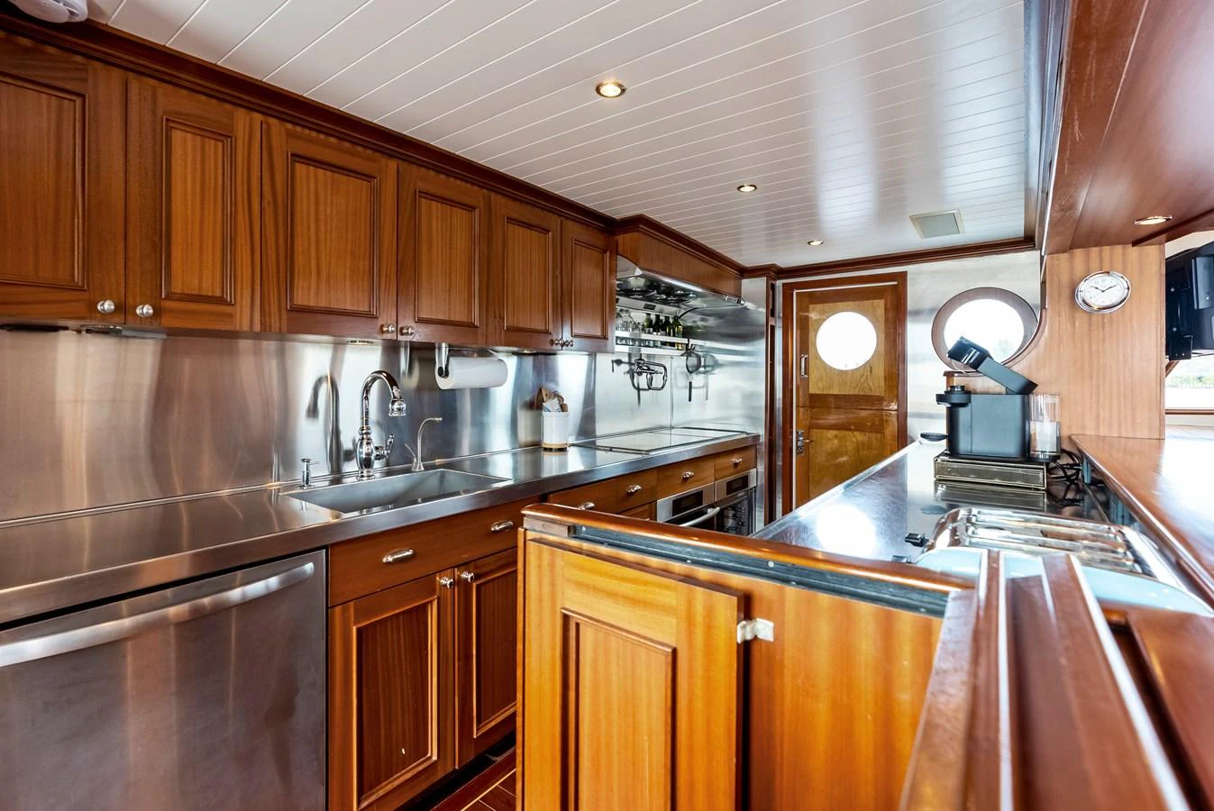 The galley features rich wooden cabinetry and modern stainless steel appliances, offering a blend of classic and contemporary design. aboard CHANTICLEER Yacht for Sale