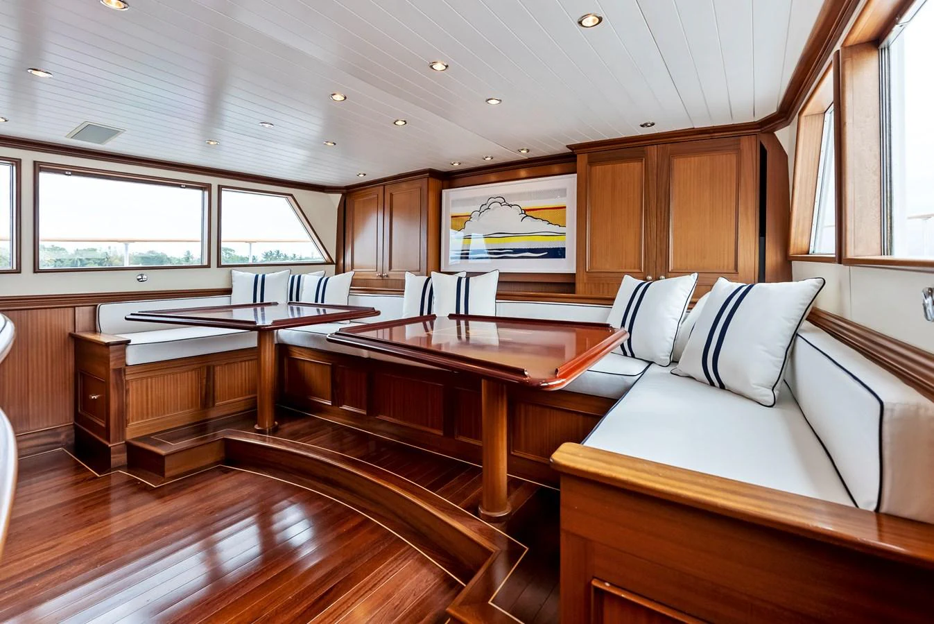 The salon features elegant wood paneling and plush seating with a nautical theme. aboard CHANTICLEER Yacht for Sale