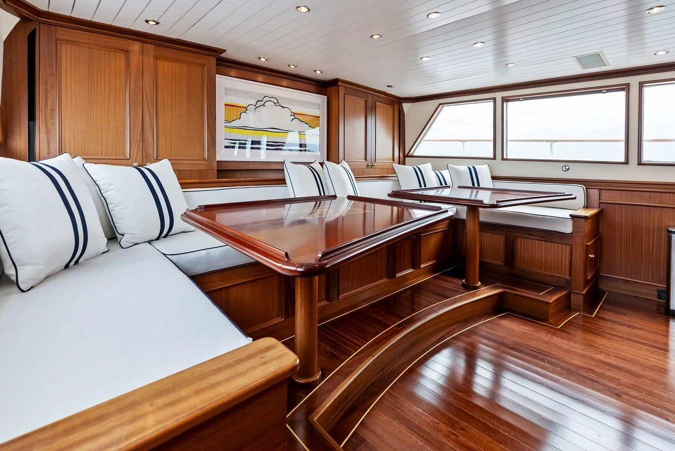 The yacht's salon features elegant wood paneling and comfortable seating with a nautical theme. aboard CHANTICLEER Yacht for Sale