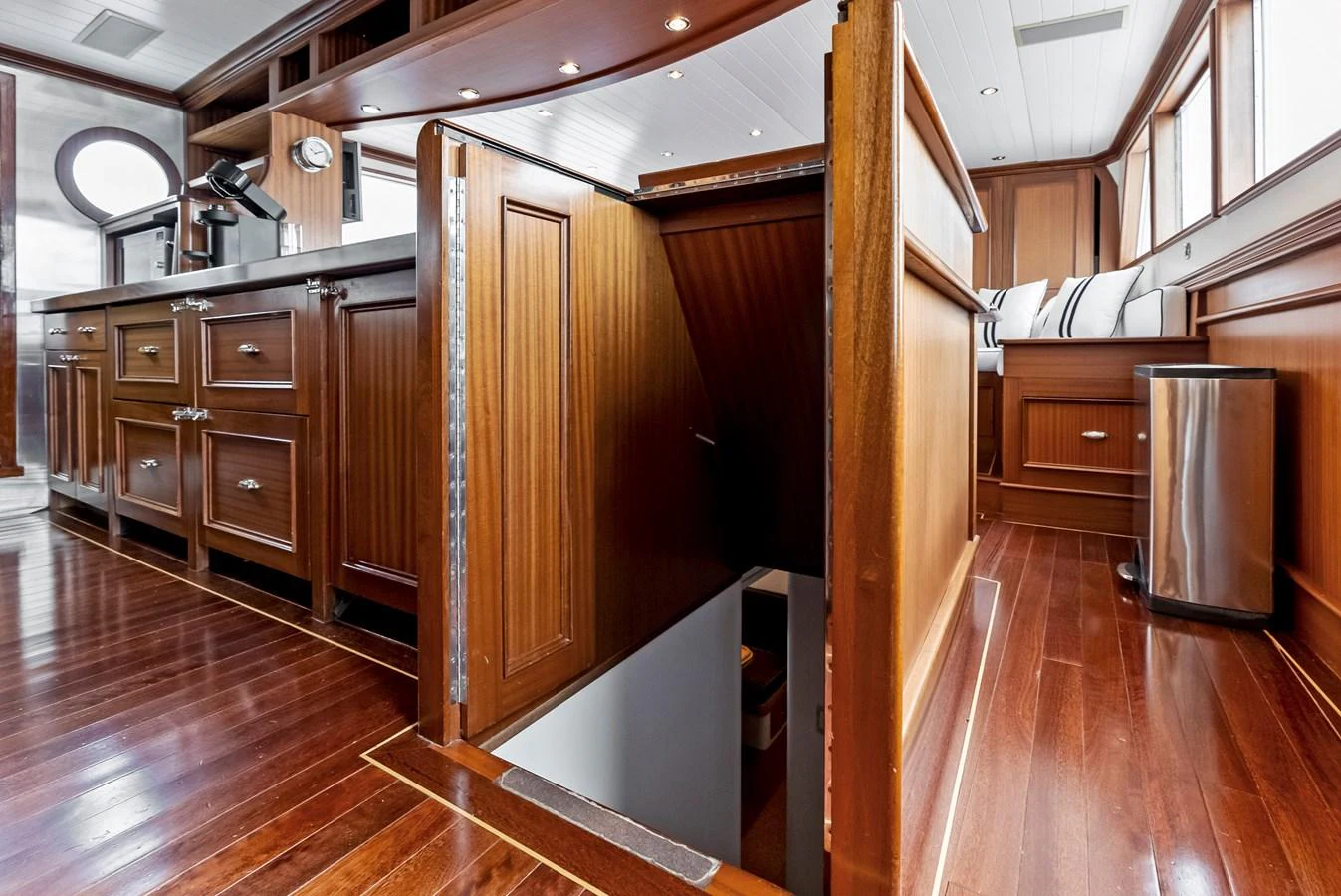 The galley features rich wood cabinetry and flooring, with a staircase leading below deck. aboard CHANTICLEER Yacht for Sale