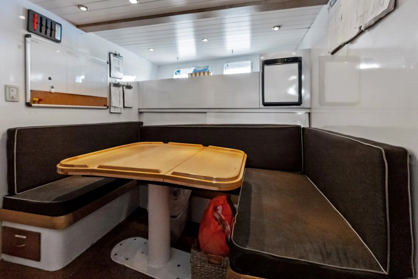 The yacht's dining area features a cozy seating arrangement with a central table, perfect for intimate meals. aboard CHANTICLEER Yacht for Sale
