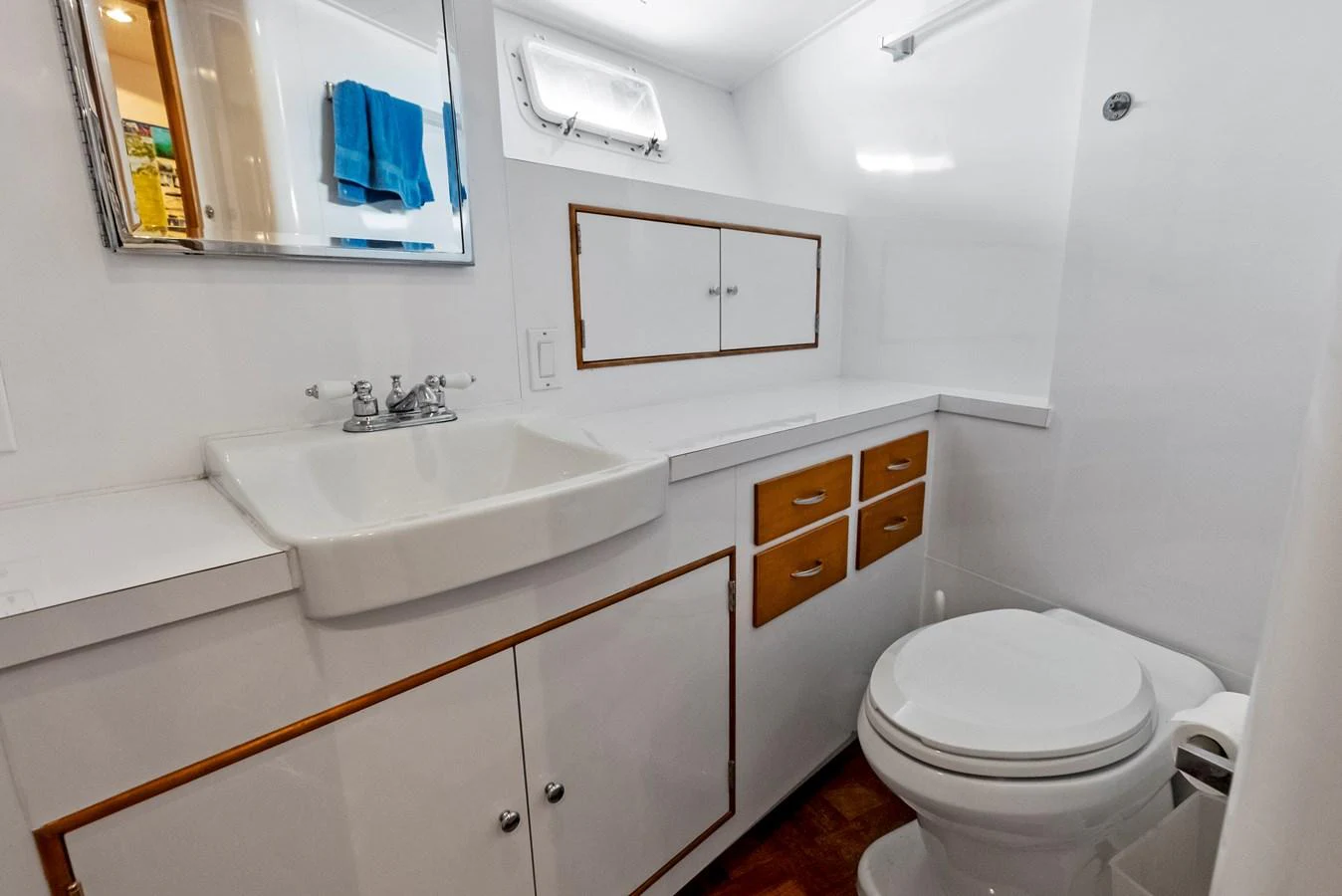 The yacht's bathroom features a clean and functional design with a sink, mirror, and storage cabinets. aboard CHANTICLEER Yacht for Sale