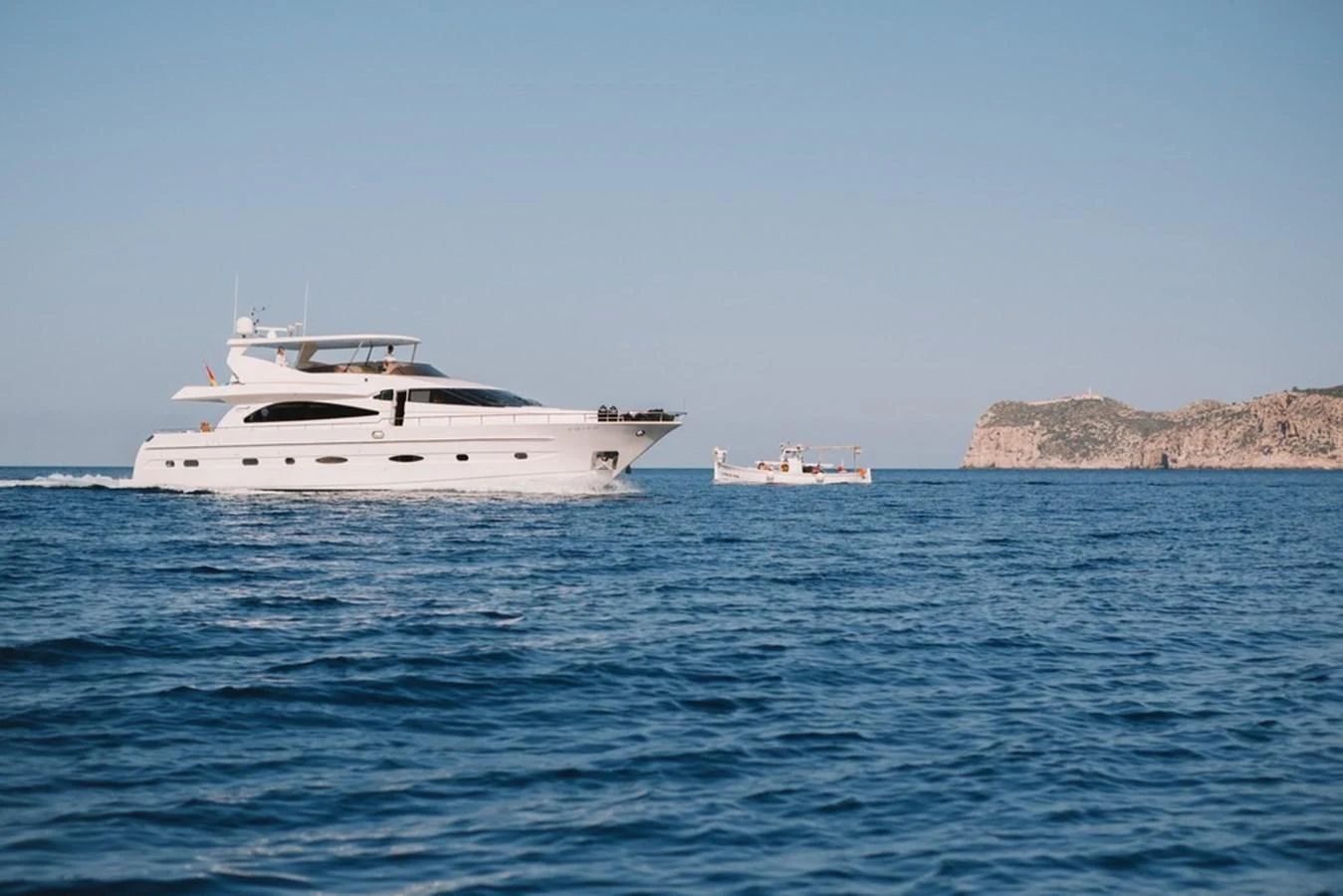 A sleek white yacht cruises on calm blue waters with a scenic coastline in the background. aboard ASTONDOA 82 GLX Yacht for Sale