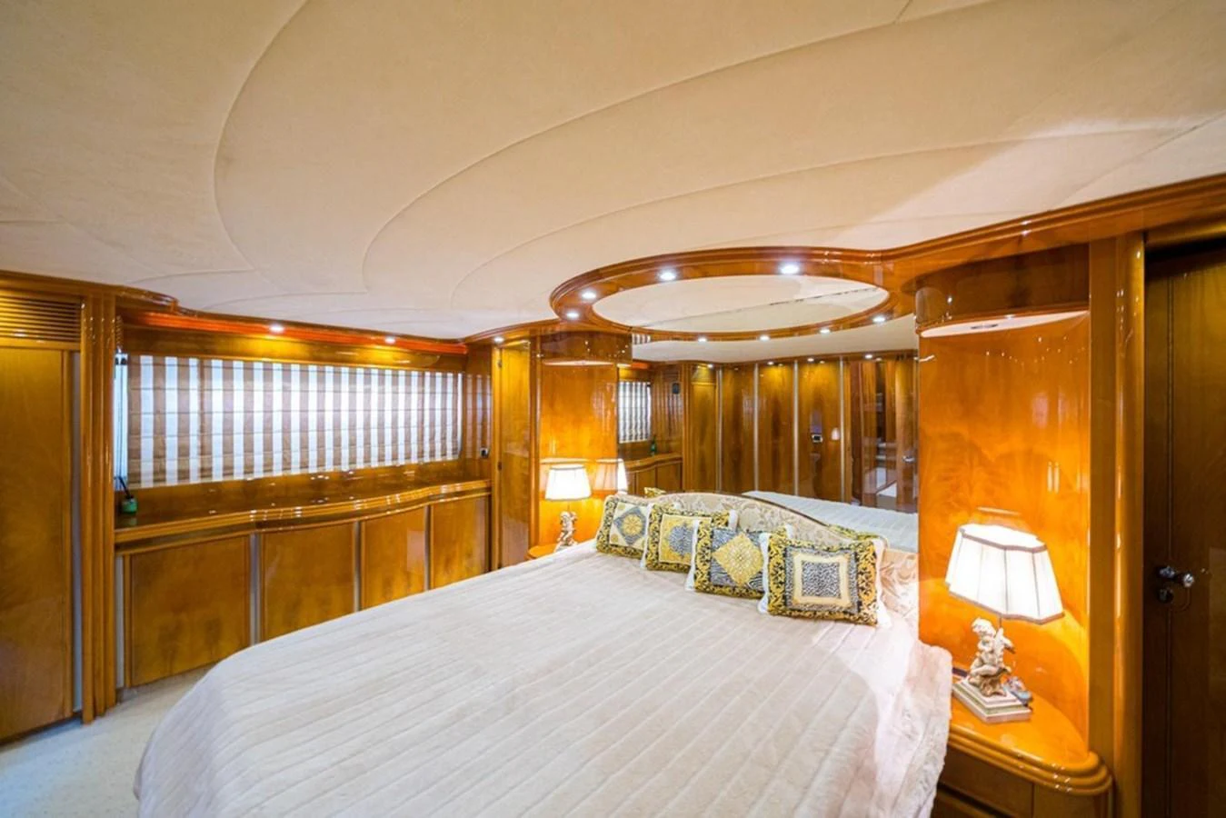 The master stateroom features a luxurious bed with elegant wood paneling and ambient lighting. aboard ASTONDOA 82 GLX Yacht for Sale
